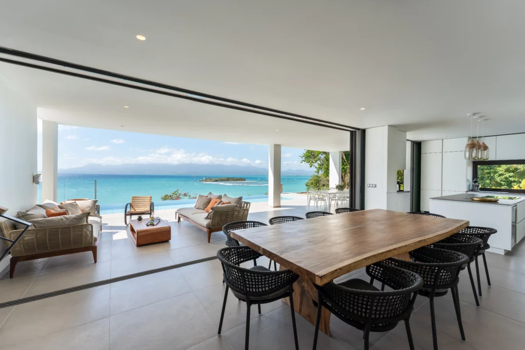 jardin moderne vue mer avec espace repas et apéro dans une villa moderne avec piscine en Guadeloupe