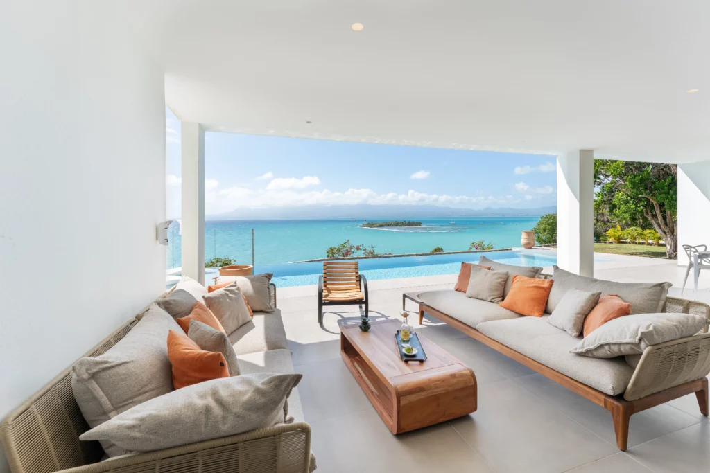 terrasse vue mer avec salon de jardin et table basse apéro dans une villa avec piscine à débordement en guadeloupe